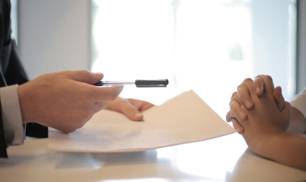 signature on an official document with a black ballpoint pen