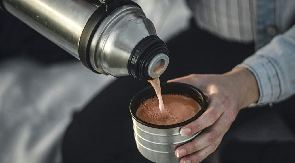 Person pouring coffee from thermos