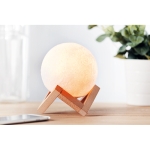 Original moon-shaped speaker with LED light on a wooden base white colour ambient view