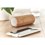 Speaker with cylindrical bamboo housing wood colour ambient view